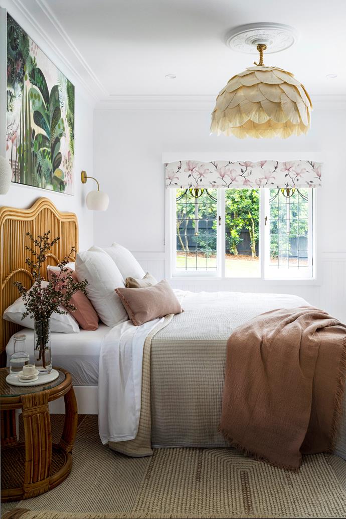 **MAIN BEDROOM** Tie it all together. Shades of pink, green and white in an artwork by Anna Rodman work wonderfully with the'Carnival' blind in Magnolia Rose from Above & Beyond Shade Solutions. A 'Petal Dome' pendant by [Bisque Traders](https://www.bisquetraders.com.au/|target="_blank"|rel="nofollow") ties in with layered bedlinen from Adairs, No Chintz and In The Sac, as well as the 'Georgia' rattan bedhead from [Adairs](https://www.adairs.com.au/|target="_blank"|rel="nofollow").