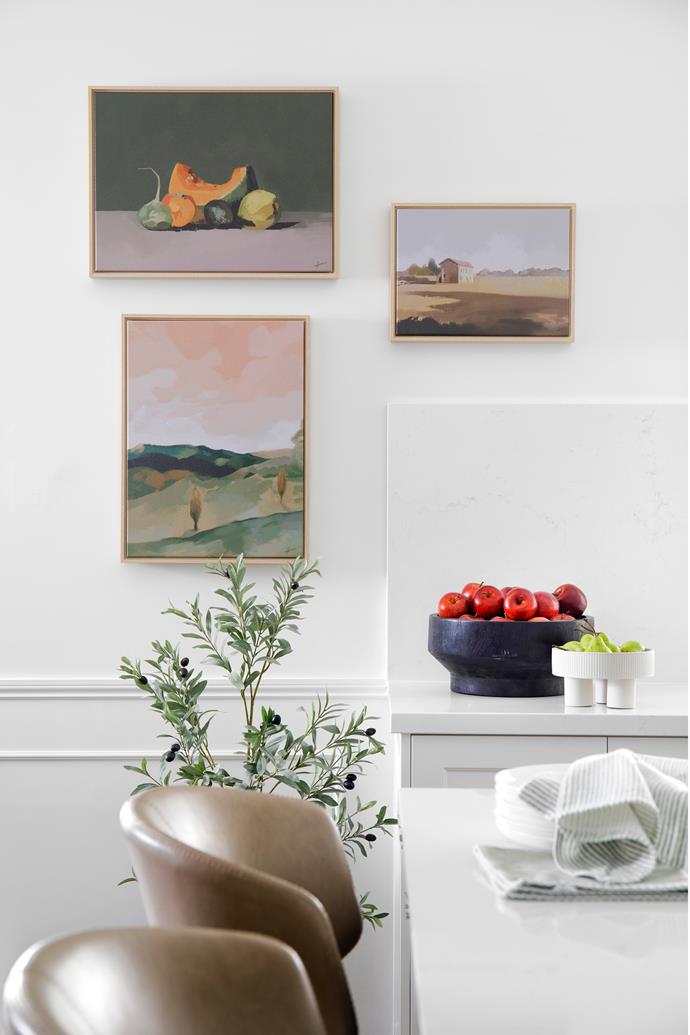 **KITCHEN** A trio of artworks by Rachel Stevens from [Palette by Jono Fleming](https://palettebyjonofleming.com/|target="_blank"|rel="nofollow") – (clockwise from top left) Still Life With Pumpkin, Tuscan Farmhouse and Rolling Hills – decorates a wall in Dulux Snowy Mountains Quarter. Franco' kitchen stools from Coco Republic look classic and are easy-clean.