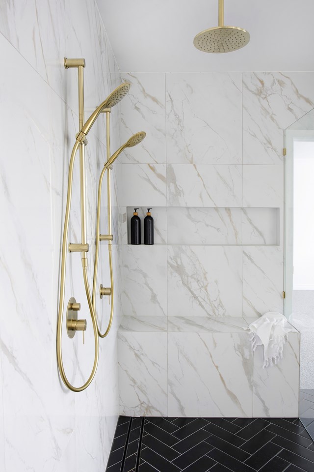 Floor-to-ceiling marble streamlines [this contemporary Gold Coast bathroom](https://www.homestolove.com.au/modern-gold-coast-waterside-renovation-23600|target="_blank") and shows how shower designs with bench seats built-in can make for easy showering at any age. It also removes the need for seating elsewhere in the bathroom.