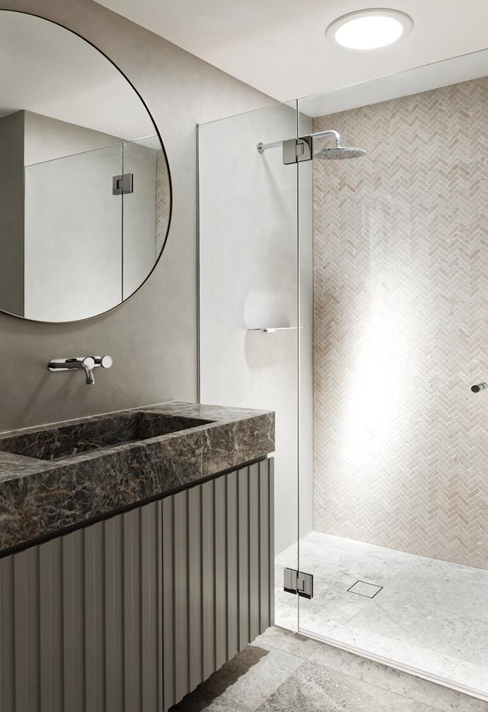 "We suggested that the bathroom be different to the rest of the apartment," says Brooke. A Vigo Lena marble benchtop from Artedomus pairs with a custom vanity in Dulux Bleaches. The curve motif appears in a round mirror from Gallery Direct.