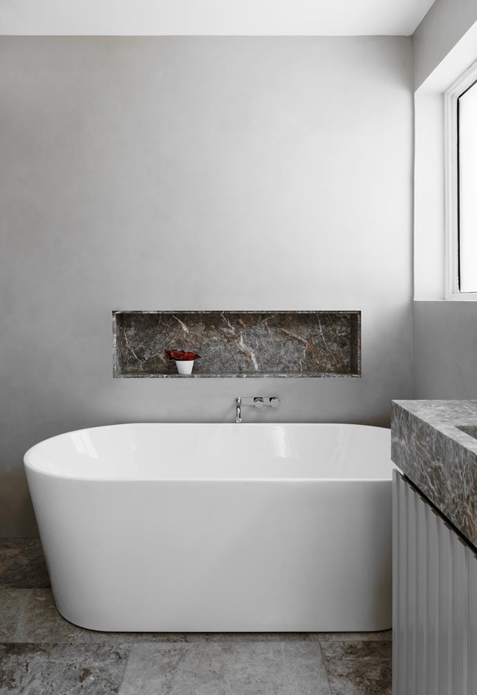 "We wanted this to feel like a light, restful space so Beverley can relax," says Brooke. A bath was her client's only request, and a round Clark freestanding tub fits the brief. Walls were finished in Microcement by Chic Coatings in a colour to match the vanity. Chambord limestone floor tiles from SNB Stone are the perfect foundation.