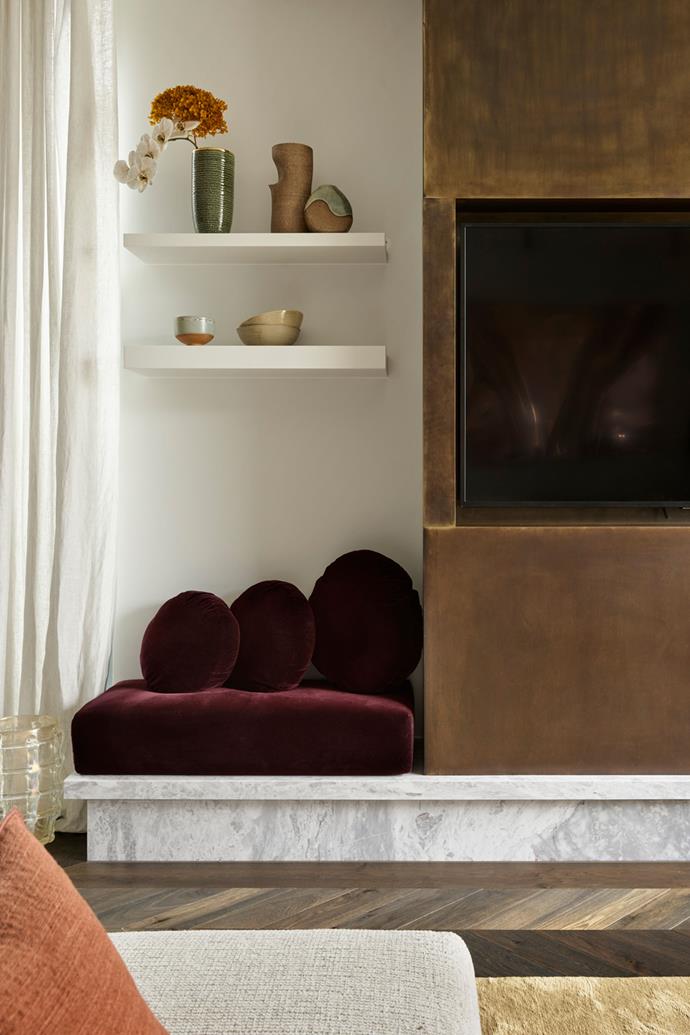 A cheeky velvet bench seat on Elba marble provides extra seating for big parties. Custom upholstery in Rubelli Velvet via South Pacific Fabrics. Custom burnished brass TV cabinet by Smac Studio. Vessels on shelf from Palmer and Penn, Saint Cloche and The Dea Store.