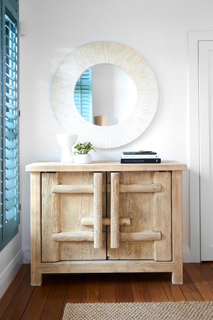 A 'Celine' bone inlay mirror from [The Boathouse Home](https://www.theboathousehome.com.au/|target="_blank"|rel="nofollow"), above the 'Bulu' timber cabinet from Uniqwa Collections.
