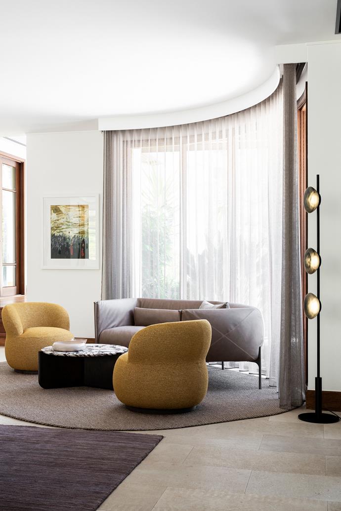 The home is set amongst verdant gardens, which remain visible even when the sheer curtains are drawn. 'Joy' swivel armchairs from [Jardan](https://www.jardan.com.au/collections/joy/products/jy80?variant=32714587668526|target="_blank") in Mustard Seed. Molinari Living 'Otto' sofa by Lucy Kurrein from Spence & Lyda. 'Millie' coffee table by SJS Interior Design from Artifex. 'Ceto' floor lamp by Ross Gardam from Stylecraft. 'Tenero' rug, The Rug Establishment. Artwork by Margaret Dimoff.