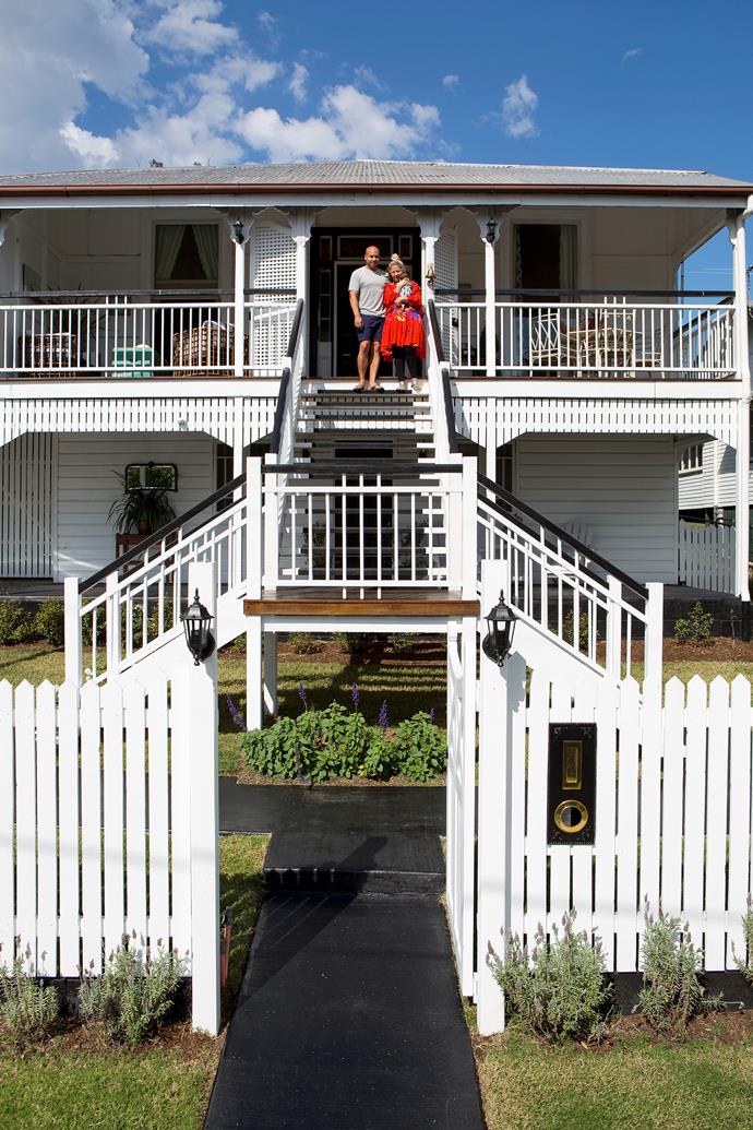 **EXTERIOR & FRONT VERANDAH** Homeowners Jeff and Amanda stand at the airy entrance of their renovated Brisbane home. The new butterfly stairs lead to the front verandah and the simply furnished hallway.