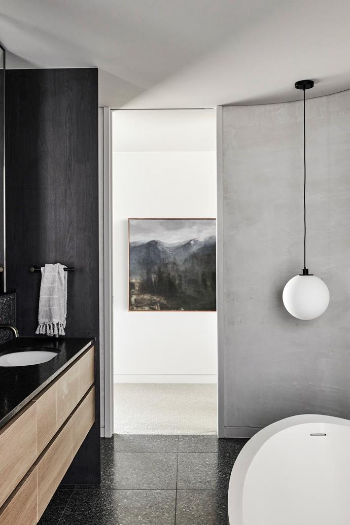 The bathrooms have a darker, [monochrome palette](https://www.homestolove.com.au/monochrome-bathrooms-6390|target="_blank") with different shades of charcoal tile used throughout. "These rooms have skylights so they are not dark, but the moodier effect is quite striking," says Sarah.