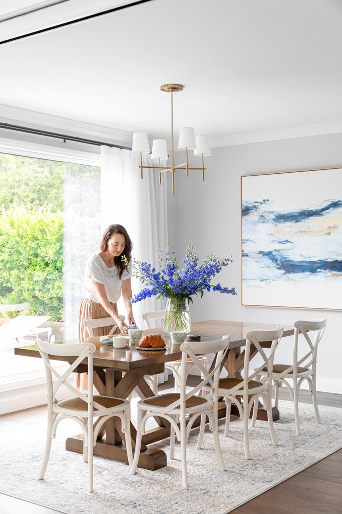 **DINING** Almira enjoys adding layers to the neutral palette of [Dulux Manorburn Double](https://www.dulux.com.au/colours/details/289876_20187|target="_blank"|rel="nofollow") walls and the dark flooring. The dining is appointed with a 'Hamptons X-Base' timber table from [Maison Living](https://www.maisonliving.com.au/|target="_blank"|rel="nofollow"), cross-back chairs from Dare Gallery and an elegant 'Bryant' light fitting from The Montauk Lighting Co. A commissioned artwork by [Chalie MacRae](https://chalie.com.au/|target="_blank"|rel="nofollow") Art and a Temple & Webster rug add a subtle touch of blue.