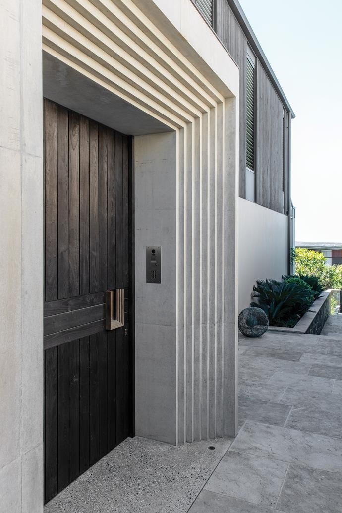 The monumental entrance with its custom door in Cambia Ash.