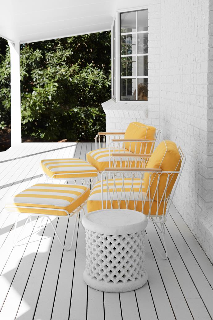 On the front verandah, armchairs from Bastille and Sons offer an ebullient pop against the white-painted brick facade and timber deck.