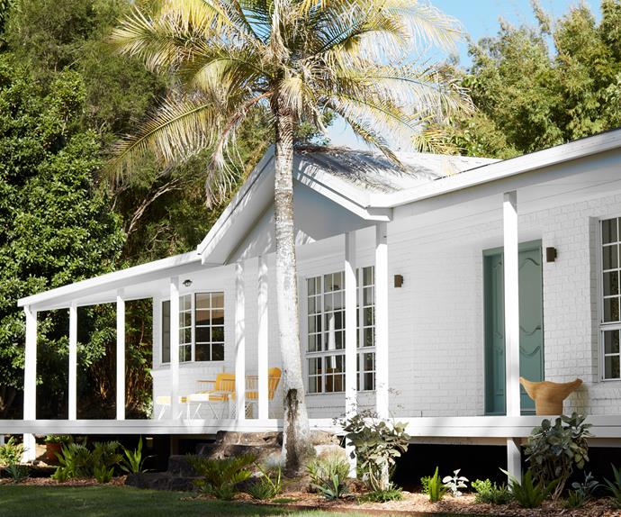 white cottage exterior with palm tree
