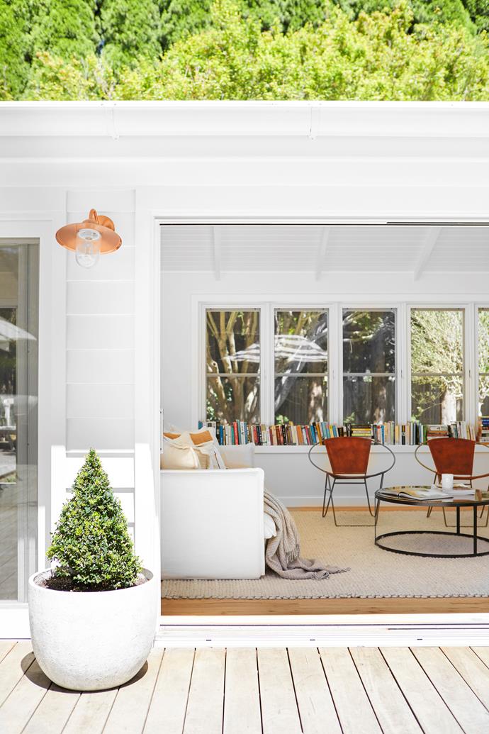 **SUNROOM** "In the original house you walked in the front door and there was a wall in front of you, totally concealing the amazing views of the [beautiful gardens](https://www.homestolove.com.au/melinda-hartwright-garden-tour-23667|target="_blank")," says Annelise. "The sunroom is designed to be a peaceful place to read, with glass everywhere to bring the outside in," says Annelise. Chairs from Hunter & Gatherer Collections, a Tribe Home rug and a coffee table from Living Interiors complete the space."I like to keep things fairly neutral and timeless, then use lighting and homewares to make the blank canvas more of a home," says Annelise.