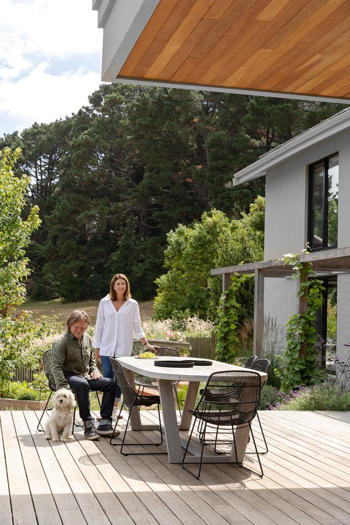 Stephen and Tanya share a quiet moment with Milly the cavoodle. Marina 'Coast' dining table and Granada 'Scoop' dining chairs, all GlobeWest. Ironbark decking. Exterior painted Dulux Grey Port.