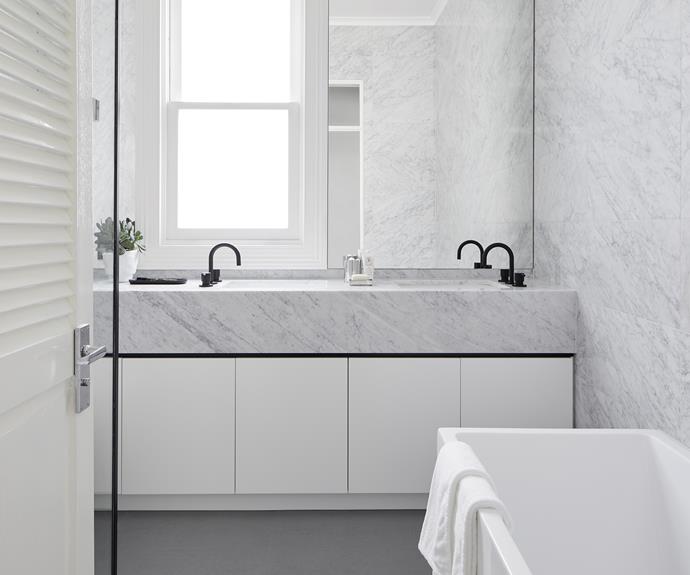 Brindabella Kitchens built the cabinetry in the bathroom, which features a Carrara marble benchtop from CDK Stone to match the wall tiles. Olivia chose Meir matte black tapware and a Caroma showerhead for the space, and Di Lorenzo floor tiles.