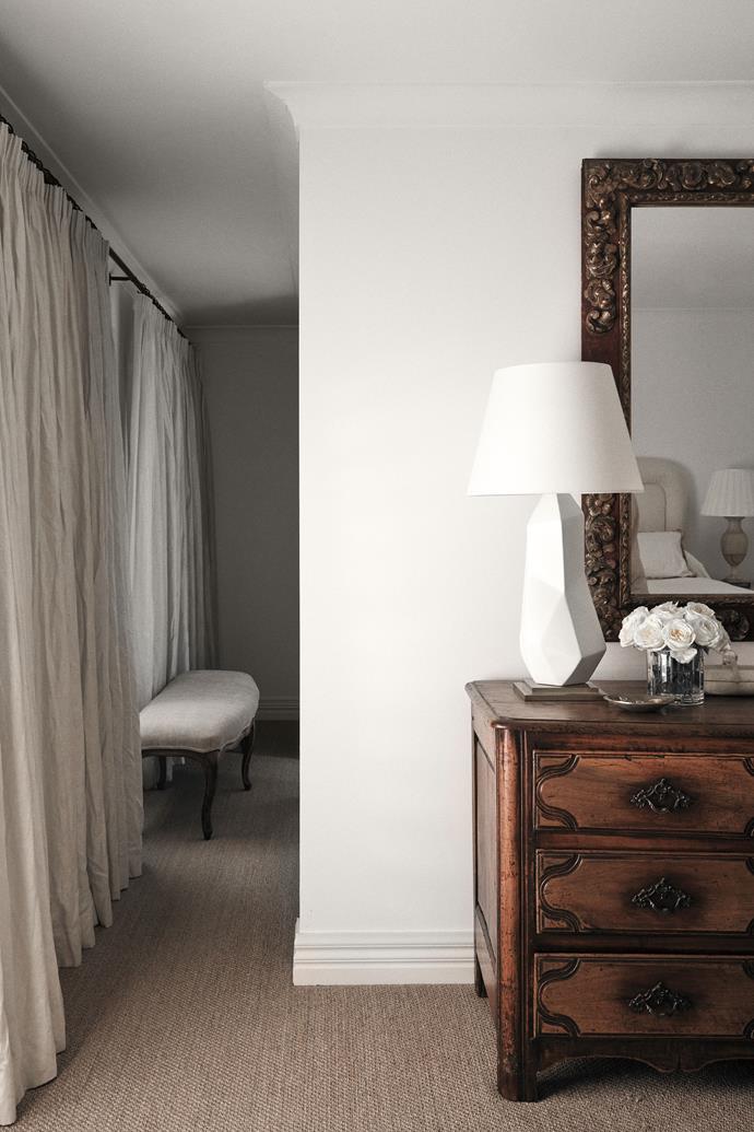 In the master bedroom, a Louis XIII French Provincial commode from The Vault Sydney beneath a 19th-century Spanish polychrome painted mirror. Kelly Wearstler table lamps from Bloomingdales. Louis XV bench seat from The Vault Sydney.