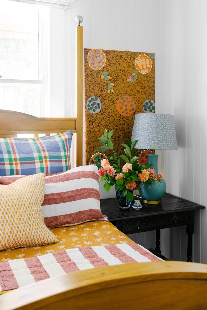 **GUEST BEDROOM** Here, the bed is flanked by custom-made [Diane Bergeron](https://www.dianebergeron.com.au/|target="_blank"|rel="nofollow") lampshades. Society of Wanderers bedlinen was purchased at [The Store Room](https://www.the-storeroom.com.au/|target="_blank"|rel="nofollow") in Toowoomba, while the Kip&Co duvet cover was bought online. Sally found the orange cushion from another local business, [Hunt & Gather Store](https://huntandgatherstore.com/|target="_blank"|rel="nofollow"), and the sycamore bed and side table were bought from the previous owners. The large dot artwork is by [Susie Napangarti Pope](https://artistsofbarkly.com.au/collections/susie-napangarti-pope|target="_blank"|rel="nofollow").