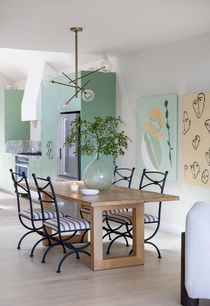 The reverence to green and cream continues in the dining area. Furnishings include a table and vintage chairs from La Tienda, art by Dani Dean for The Make Haus and an Atelier Slipper chair in Boucle Ivory  from Coco Republic.