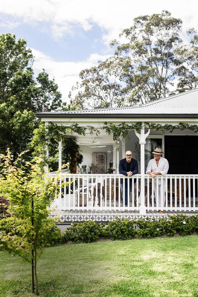 Country life suits treechangers Neale Whitaker and his partner David Novak-Piper, seen here on the verandah of their renovated home. The garden, planted by David, is a "beautiful work in progress" says Neale. A row of gardenias edges the verandah, wisteria trails above and a freshly planted maple sits out the front.