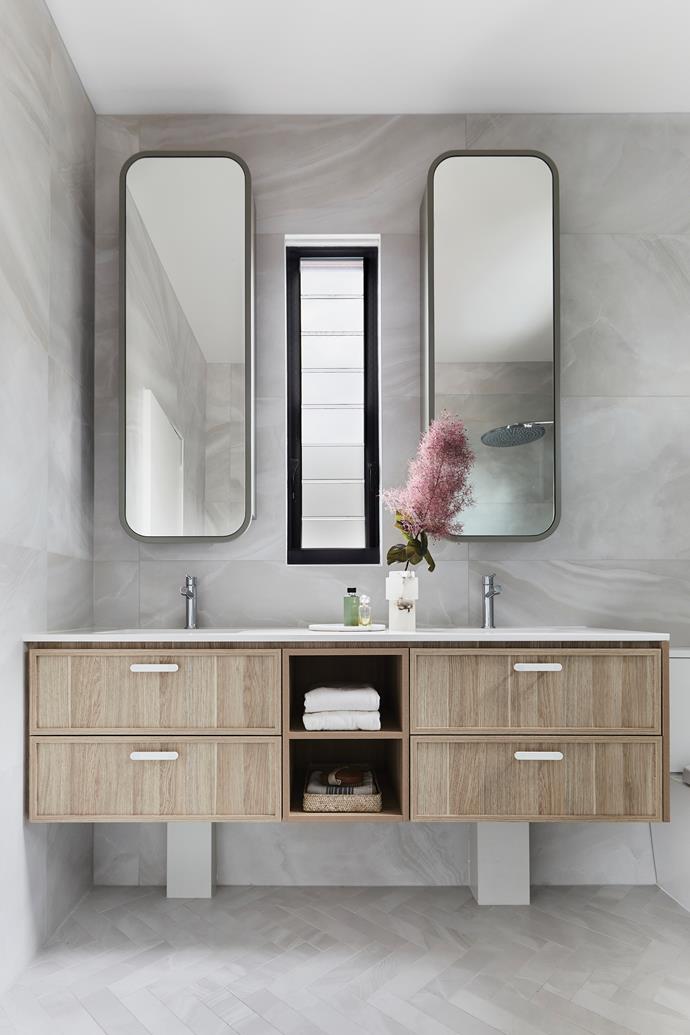 Long rectangular mirrors with [Dulux](https://www.dulux.com.au/|target="_blank"|rel="nofollow") Eyre surrounds mimic the shape of the window. The custom joinery in [Laminex](https://www.laminex.com.au/|target="_blank"|rel="nofollow") Classic Oak is by [In Vogue Kitchens & Joinery](https://www.invoguekitchens.com.au/|target="_blank"|rel="nofollow"). Benchtop, Silestone Nebula Miami Vena by Cosentino. Wall tiles, Nolita Bianco Satin from Di Lorenzo. Floor tiles, as before in a herringbone format.
