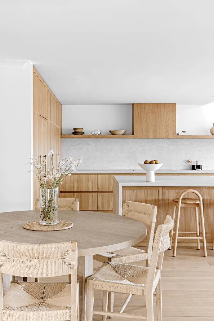 From this angle, the seamless look of the kitchen with its continuous [open-shelf design](https://www.homestolove.com.au/kitchen-shelf-ideas-20224|target="_blank") is apparent. Kate achieved this by closing in two existing windows on the back wall. "It doesn't look any darker now because we chose a fresh colour palette — you don't even notice they've gone!" she says. At breakfast time, or when it's just Rhonda and Bruce at home, a round table from [Freedom](https://www.freedom.com.au/|target="_blank"|rel="nofollow") and woven chairs from [MCM House](https://www.mcmhouse.com/|target="_blank"|rel="nofollow") ably fit the bill.