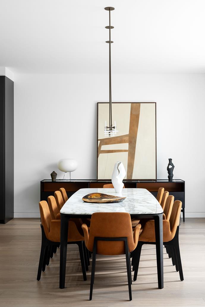 Rich ochre and chocolate hues bring warmth to the dining area. 'Henry' dining table with Calacatta Oro marble top and black elm legs, 'Code' sideboard and 'Ventura' dining table, all from Poliform. Custom pendant light designed
by Blue Label Design and made by Søktas. Lacena sculpture on dining table by Emily Hamann from Curatorial+Co. ['Pebble' platter from Dinosaur Designs](https://davidjones.k98d.net/c/3001951/378297/5504?&u=https://www.davidjones.com/product/dinosaur-designs-large-leaf-bowl-in-chalk-swirl-24973448?nav=939228|target="_blank"|rel="nofollow"). Small vase on sideboard from The DEA Store. Foscarini 'Buds 2' table lamp from Space. Black Onishi vase by Kerryn Levy from Curatorial+Co. Sweet Confinement artwork by Morgan Stokes from Curatorial+Co.
