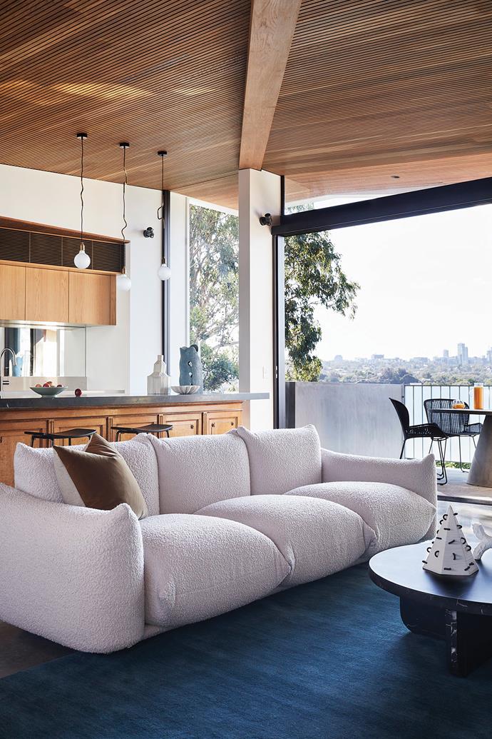 **KITCHEN/LIVING** The timber ceiling adds warmth to the monochrome palette of the new extension. Extending the timber over the balcony and unframed windows blurs the lines between indoors and out, while the mirrored splashback reflects the view. Sofa, [Space](https://www.spacefurniture.com.au/|target="_blank"|rel="nofollow"). Pendant lights, [Volker Haug Studio](https://www.volkerhaug.com/|target="_blank"|rel="nofollow").