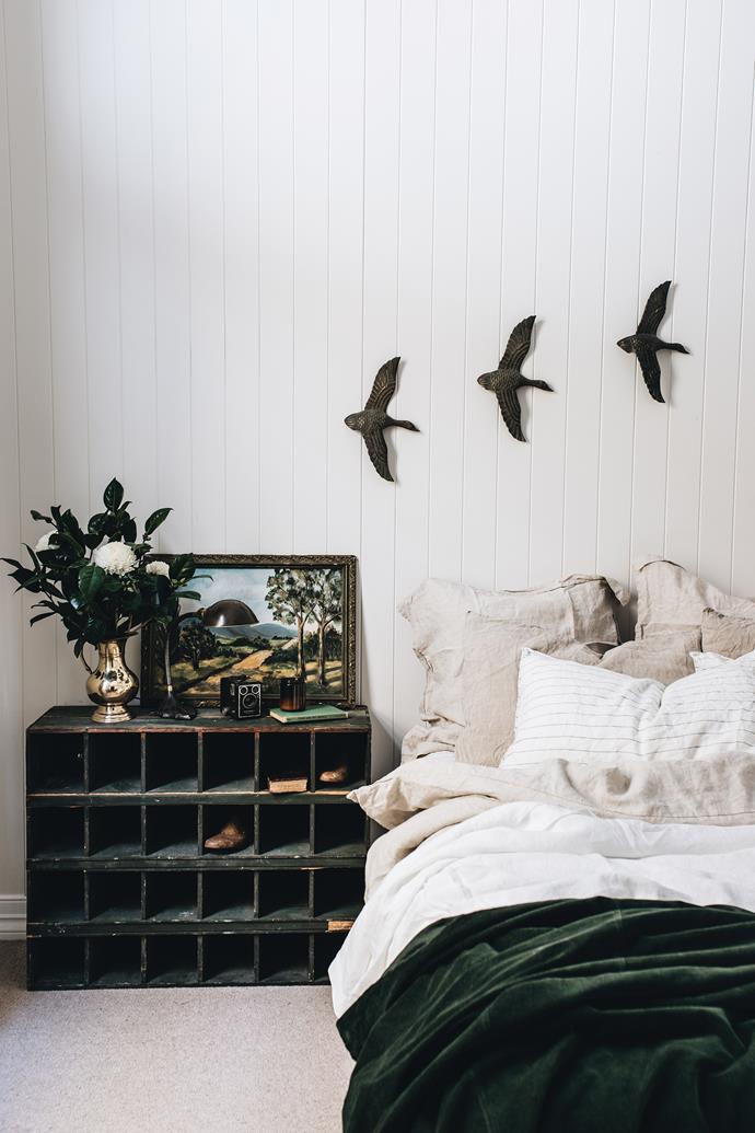 Vintage brass ducks fly over pigeonhole shelves from Daylesford Mill Markets and [Carlotta + Gee](https://www.carlottaandgee.com/|target="_blank"|rel="nofollow") bed linen. The painting is from Dookie Emporium.