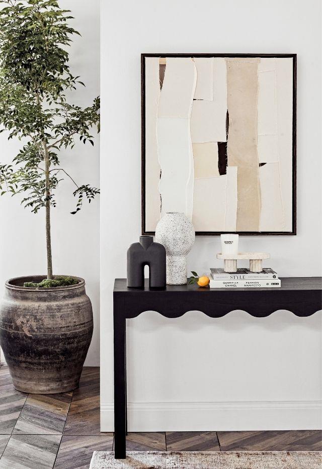 Collate homewares from the same tonal family, which can be informed by a particular artwork. Pictured here is the Jilin terracotta pot from Papaya, the painting 'What to Remember When Walking' by Morgan Stokes (go to Curatorial + Co) and the Audrey console from McMullin & Co.
