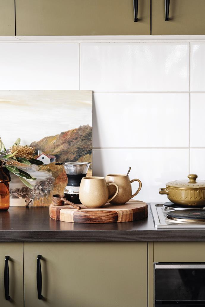 The [kitchen was already painted olive green](https://www.homestolove.com.au/green-kitchens-21173|target="_blank"), which suited the new look perfectly. Modern door handles and shelving updated the space.