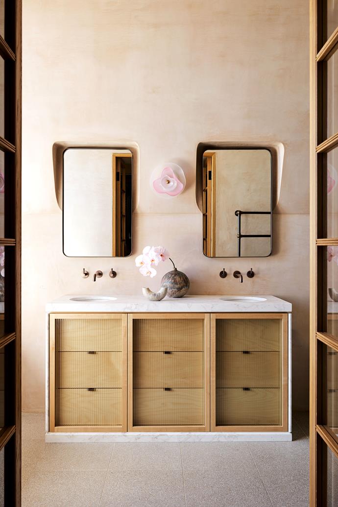 Softly does it with the serene blush ensuite bathroom of this [colourful Federation home](https://www.homestolove.com.au/colourful-federation-home-inner-west-sydney-23868|target="_blank") in Sydney's inner west. The sculptural 'Petal' wall light from Studio & Co perfectly complements the hardy Italian terrazzo floors.