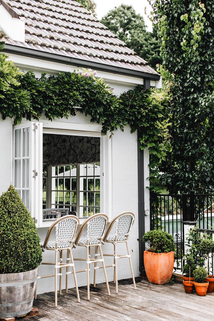 The charm of this [storybook-like home](https://www.homestolove.com.au/grand-hamptons-cottage-southern-highlands-23870|target="_blank") in the NSW Southern Highlands flows through both its interiors and its exteriors. Using bar stools sourced from eBay, couple Melinda and Tom have transformed this alfresco deck into a breakfast bar framed by wisteria.
