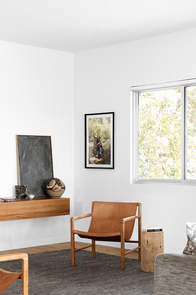 [DPR Joinery](https://www.instagram.com/dpr_joinery/|target="_blank"|rel="nofollow") built much of the cabinetry throughout the home, including this floating blackbutt shelf, on which sits an artwork by [Ben Parker](https://bluethumb.com.au/ben-parker|target="_blank"|rel="nofollow") called 'First Majestic' and a vintage vase. Leather armchairs from [Worn](https://wornstore.com.au/collections/furniture|target="_blank"|rel="nofollow") and a custom timber side table and woven rug from [Huset](https://www.huset.com.au/|target="_blank"|rel="nofollow") complete this cosy nook. On the wall hangs a family photo of Hannah with her mother, Barbara, and sister, Kate, from 1979.