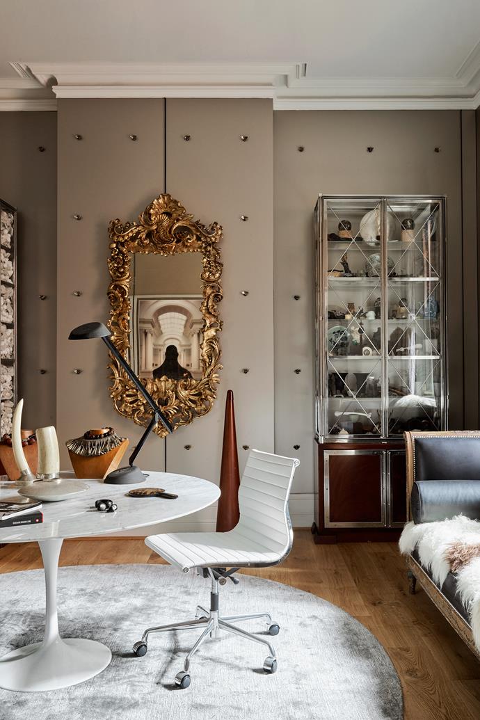 The showroom and viewing room on the ground floor was designed by Alexander. Formerly black, the walls are now anodised aluminium panels studded with gilded bumblebees. The cabinet is filled with finds from Tony's travels that were inspiration for his jewellery. On the Knoll 'Tulip' table the necklaces on the busts are African silver with Venetian glass beads. The tusks are set on silver bases. An artwork by Alexander is reflected in the mirror.