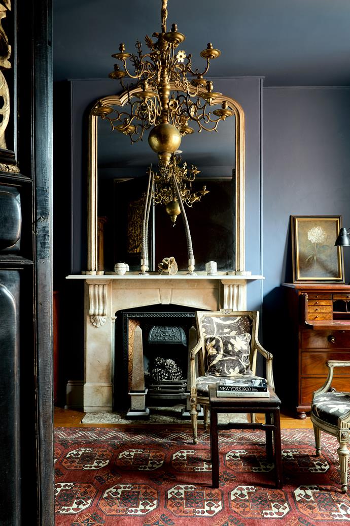 In the second bedroom, which also serves as a study, a pair of 18th-century Italian chairs and on the mantelpiece a pair of gazelle antlers mounted on silver by Tony. A botanical work by Paul Jones rests on the writing desk. The antique chandelier is Russian. The ornate Chinese doors lacquered in black and gold are also antique.