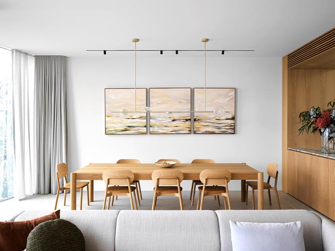 In the dining space, Rolled Together triptych artwork by Stefania Reynolds. 'Huxley' table and 'Mckenzie' chairs from Jardan. 'Ceto' pendant light from Ross Gardam. Timber veneer joinery by Sublime Custom Cabinetry. Erik Jørgensen 'Konami' three-seater sofa from Cult.