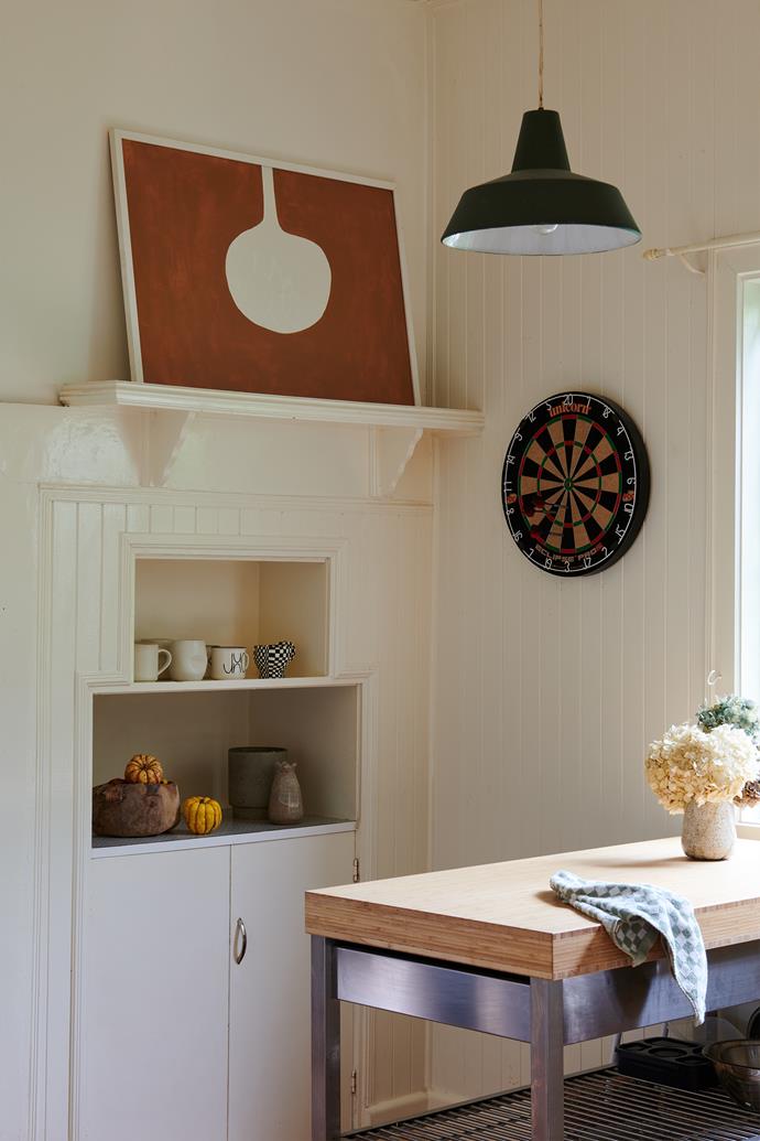 Even the kitchen is a treasure trove. The art on the mantel is by Bobby Clark; the various ceramics are from [The Soda Fountain](https://the-soda-fountain.com/|target="_blank"|rel="nofollow"), [James Lemon](https://james-lemon.com/collections|target="_blank"|rel="nofollow"), [Perla Valtierra](https://perlavaltierra.shop/|target="_blank"|rel="nofollow") and [Anchor Ceramics](https://www.anchorceramics.com/|target="_blank"|rel="nofollow"). The vase on the butcher's block is by [Amy Leeworthy](https://www.amyleeworthy.com/|target="_blank"|rel="nofollow"), while the pendant light is an iconic [IKEA](https://www.homestolove.com.au/tags/ikea|target="_blank") piece. The wall has been refreshed with Dulux Antique White.