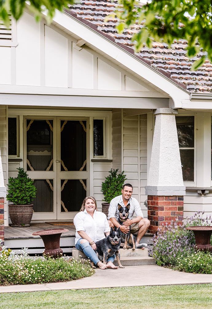 Homeowners Jim Ferguson and Emily McEachern sit on the verandah steps of their archetypal [Californian bungalow](https://www.homestolove.com.au/the-farmstead-tatura-goulburn-valley-24061|target="_blank") in the Goulburn Valley. Surrounding them is a rambling garden full of roses, lush lawns and fruit trees.