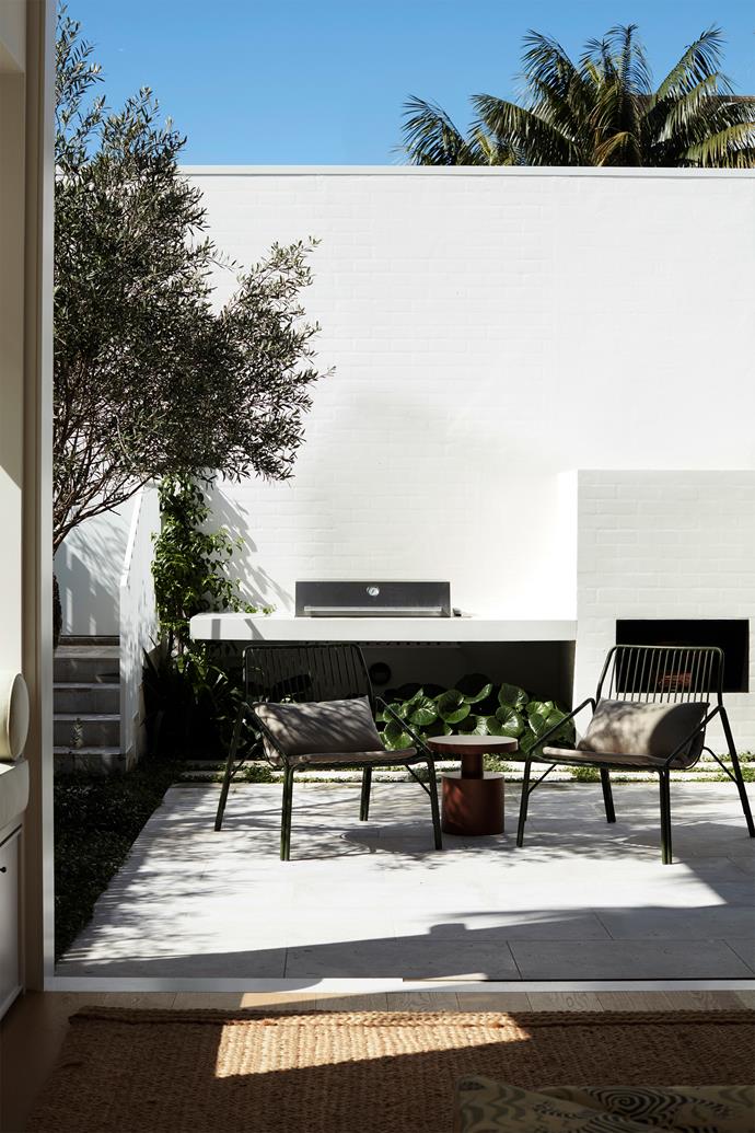 In this character-filled renovation of a Federation home in Sydney, an outdoor kitchen and dining area are integrated seamlessly into the backyard design. White masonry walls and dark accents give the home an ultra-modern feel.