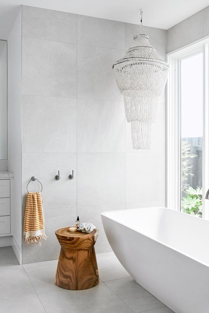 Full-length windows give this New Hamptons style bathroom a sense of luxury, with a shell chandelier adding some lovely coastal vibe.