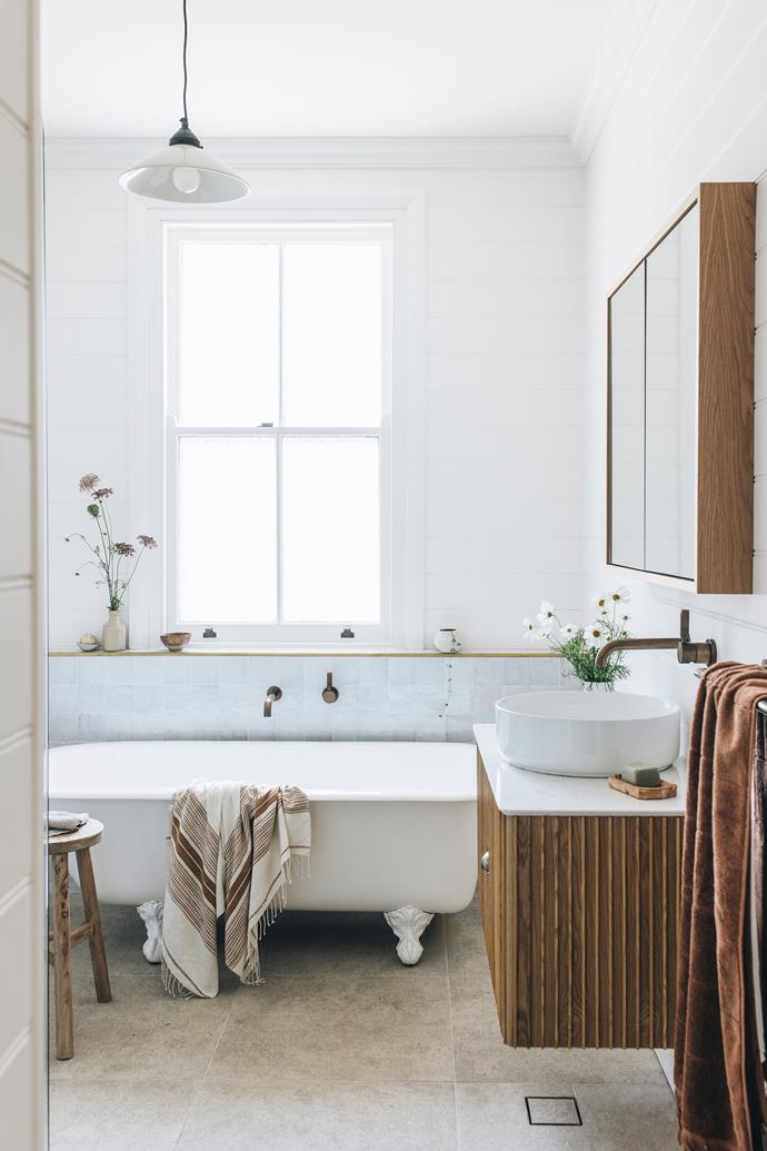 Refined country style makes the bathroom of this [renovated heritage cottage in Mittagong](https://www.homestolove.com.au/renovated-heritage-cottage-mittagong-nsw-24689|target="_blank") a serene dream. A classic clawfoot bath is modernised thanks to simple large floor tiles and a warm-toned timber vanity.