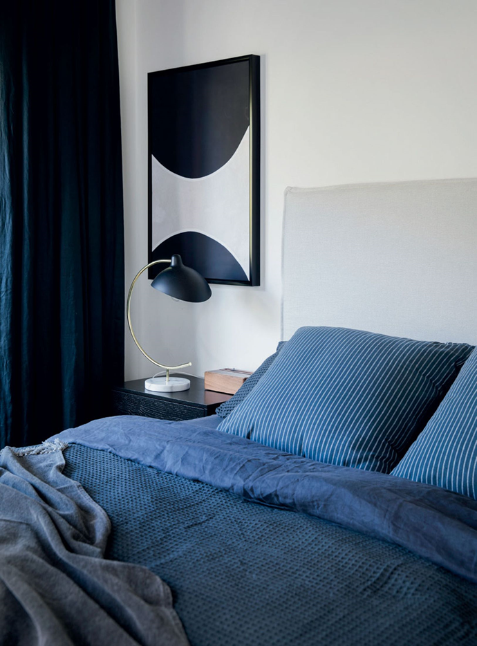 Simple and streamlined, Benji's bedroom combines the deep blues of Pillow Talk linen with an understated bed and artwork from Zanui and curtains from Drape Co.