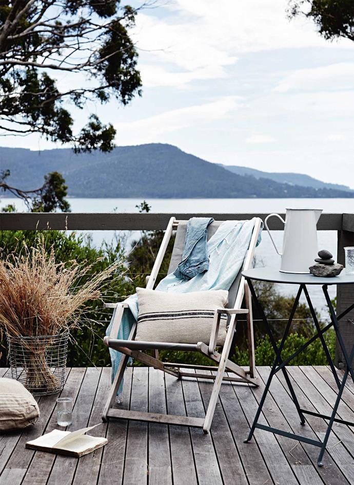 A deckchair and table create a spot to unwind and shuck oysters on the deck.