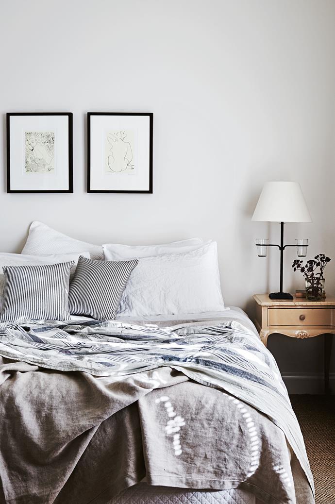 Layers of relaxed linen and a pair of minimalist artworks keep the master bedroom feeling modern.