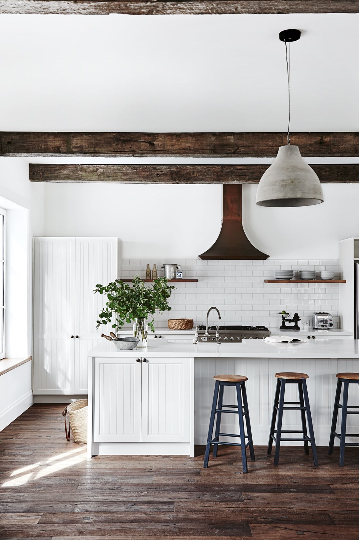 The kitchen features a copper range hood salvaged from a warehouse demolition.