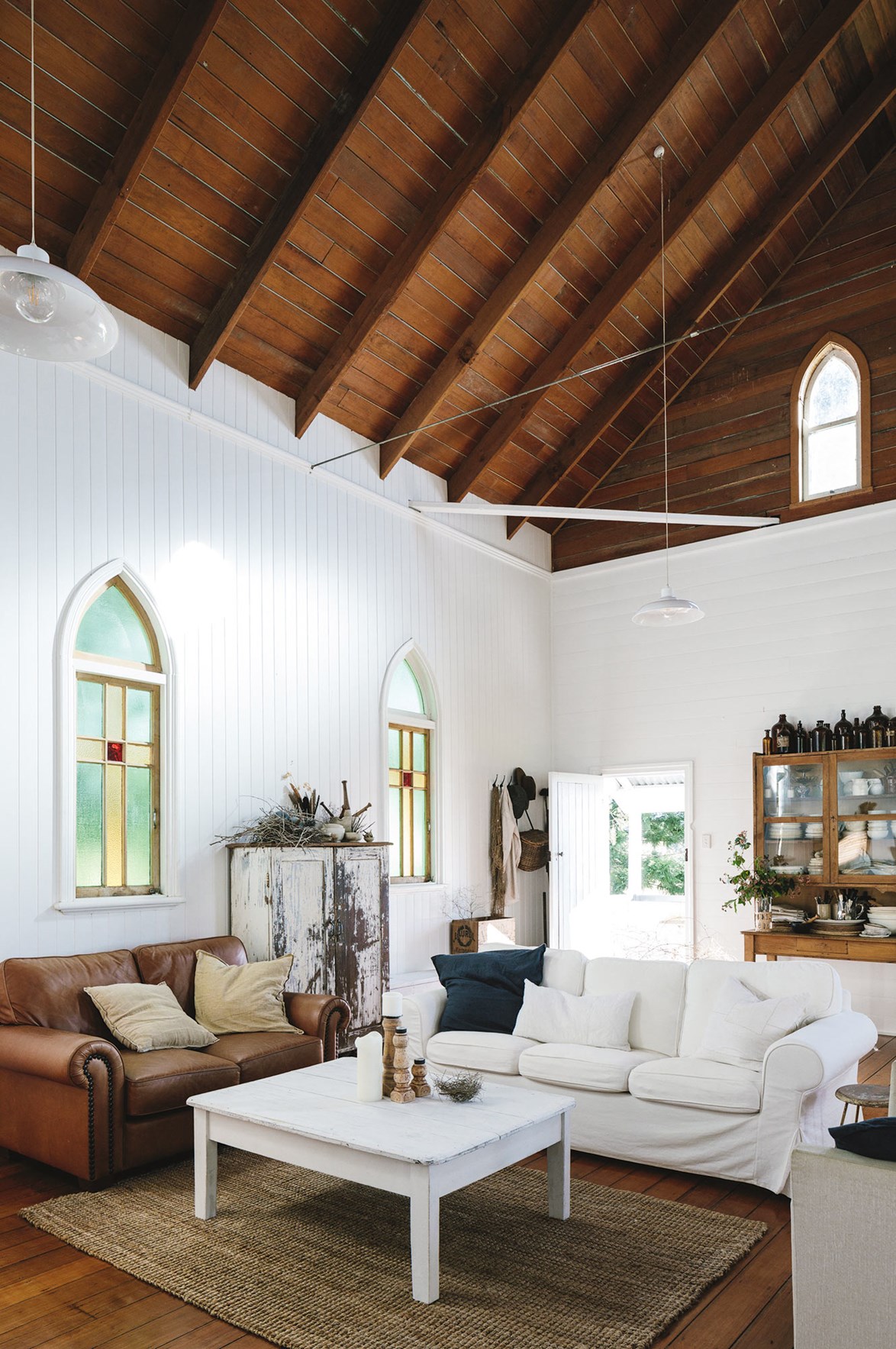 A divine living room was created in this open-plan [church-turned-home](https://www.homestolove.com.au/restored-qld-church-full-of-divine-treasures-13984|target="_blank"). A natural colour palette echoes the timber tones of the impressive cathedral ceiling. "I love things that are weathered and tell the story of where they came from," says the homeowner.