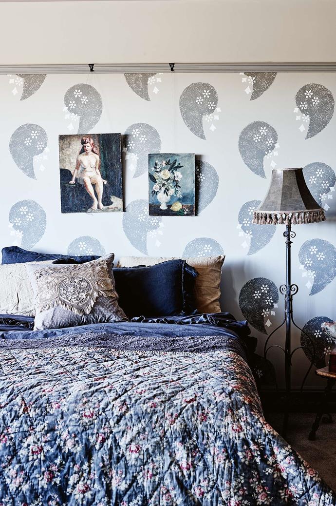The paisley designs on the wall in the main bedroom were hand-stencilled by Kate. The paintings were sourced online, while the lamp stand was picked up at an antiques fair in Fryerstown.
