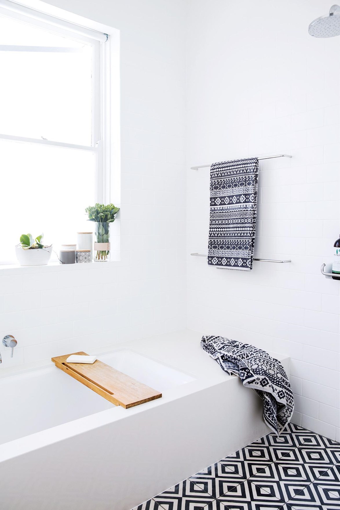 This minimalist white bathroom in a [light filled terrace house](https://www.homestolove.com.au/minimalist-inspiration-from-a-light-filled-terrace-18366|target="_blank") in Sydney's eastern suburb of Paddington is anything but dull with black and white patterned floor tiles. "All our homes have been bright and full of light, but we have experimented with colour – starting with vibrant shades, then moving into neutral tones and finally to my favourite – white," says owner Sarah.