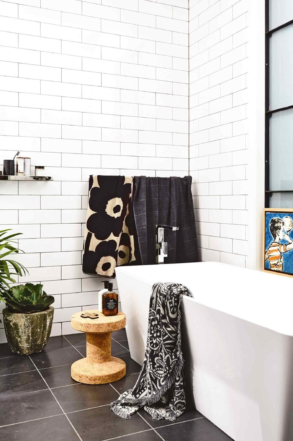 While a white bathroom will likely never go out of style, they can suffer from looking run-of-the-mill and clinical. Avoid this happening to you by accessorising with patterned towels and other textural objects like a cork stool or cement planter. *Photo: Derek Swalwell / Styling: Rachel Vigor*