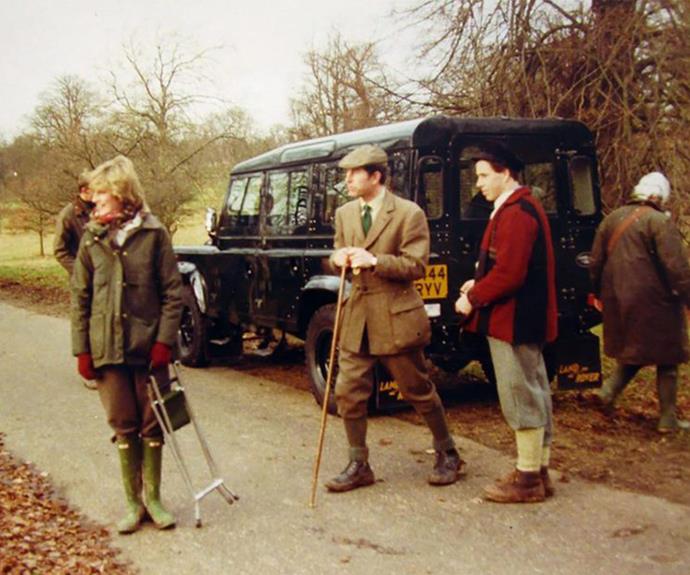 Ready for a day of hunting, a rugged up Diana holds onto a fold-out chair as Prince Charles follows behind her. **(Image/Littleton Auctions)**