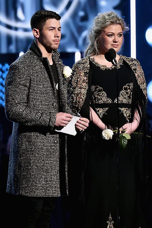 Nick Jonas and Kelly Clarkson take to the stage to present an award.