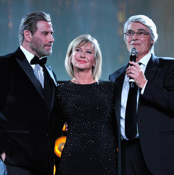 John Travolta and Olivia Newton-John were joined onstage by Australian-born music producer and songwriter John Farrar who wrote the musical numbers in *Grease*.